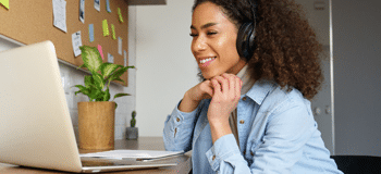 mulher negra ao telefone olhando para o notbook